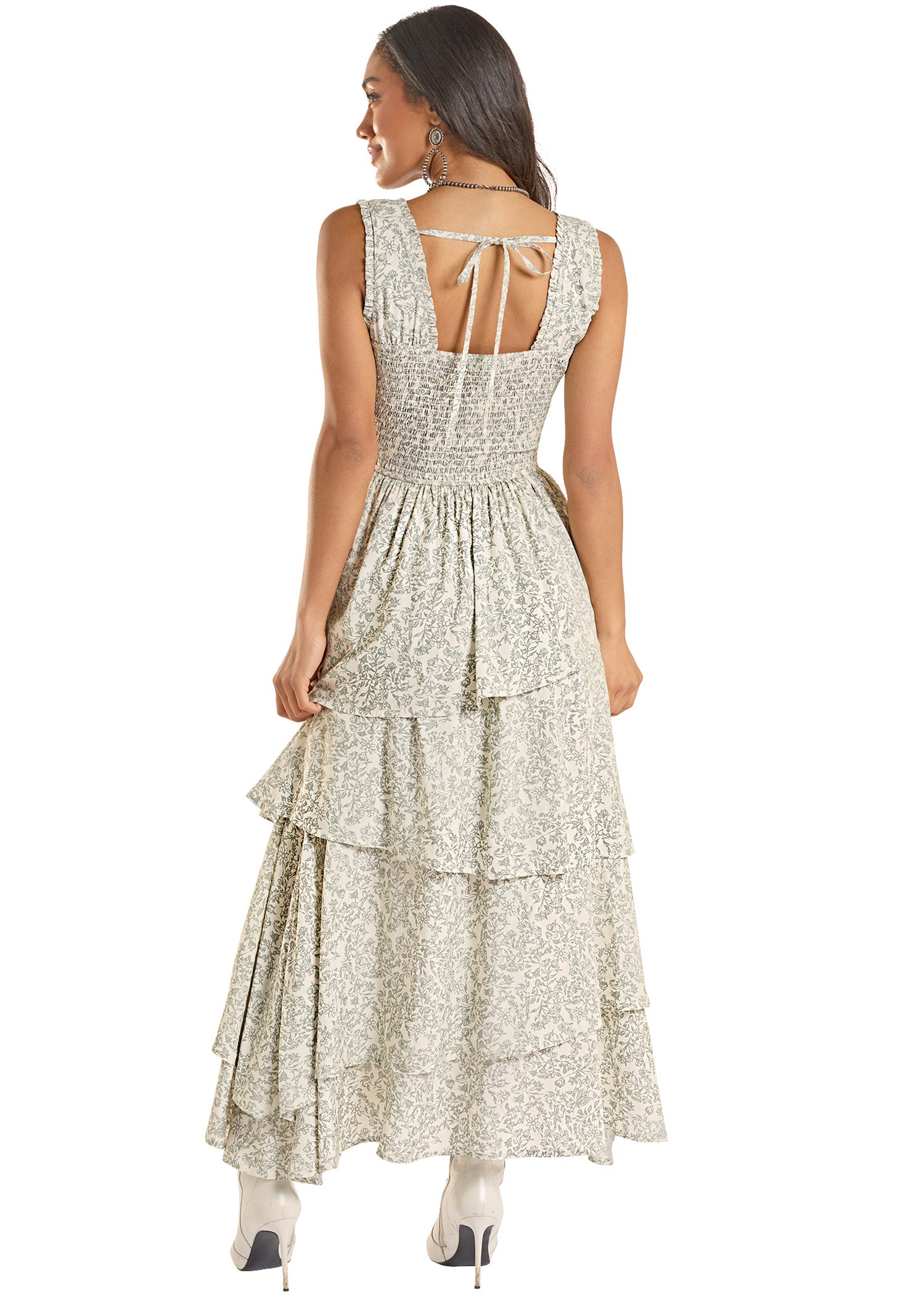 Woman wearing a floral dress with ruffled layers on a white background