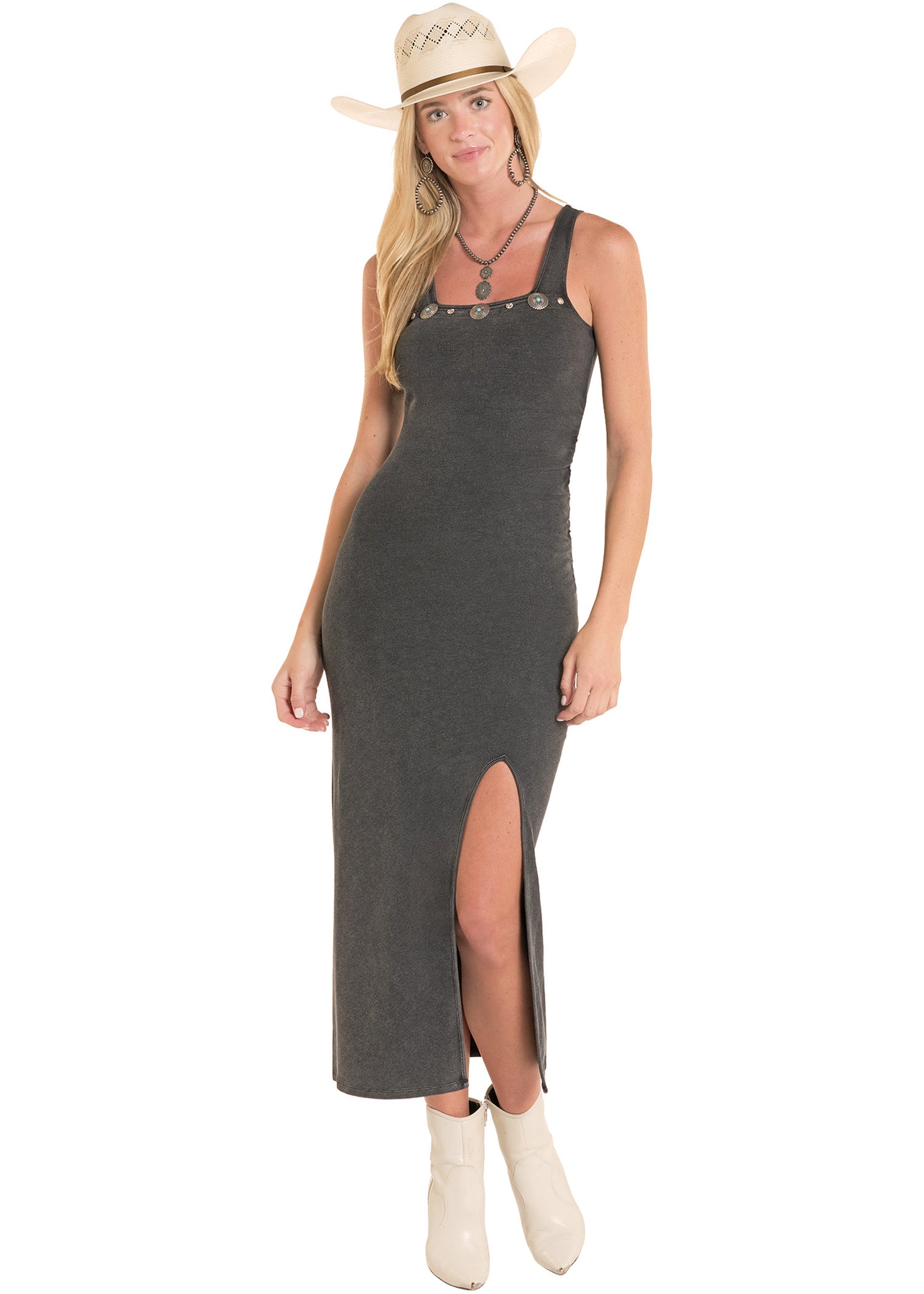 Woman wearing a black dress with buttons and a slit, standing against a white background