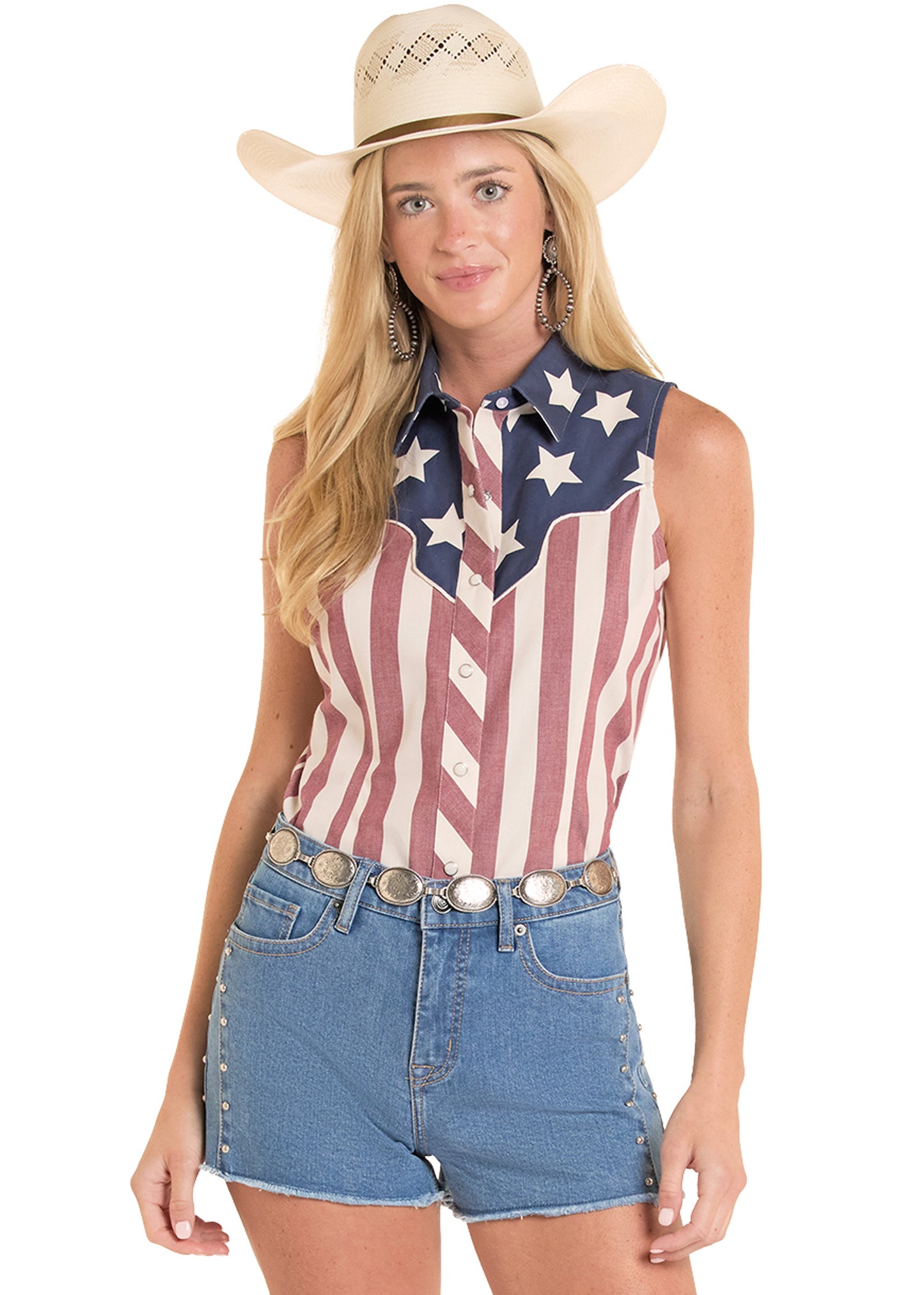 Woman wearing a sleeveless shirt with an American flag design and denim shorts on a white background