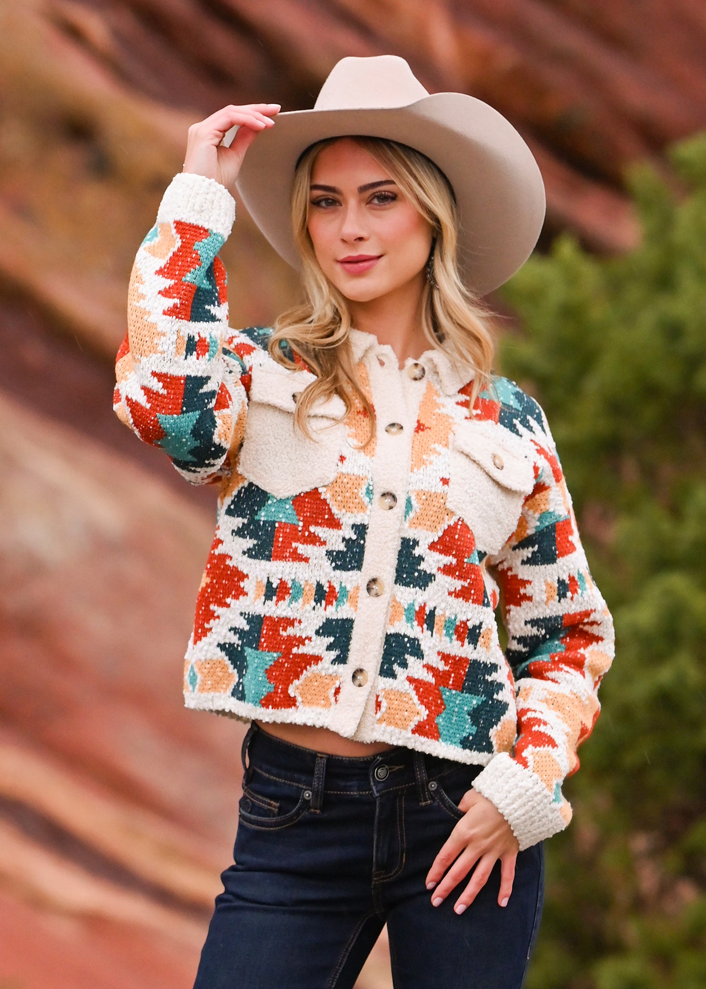 Woman wearing a colorful patterned jacket and beige hat outdoors