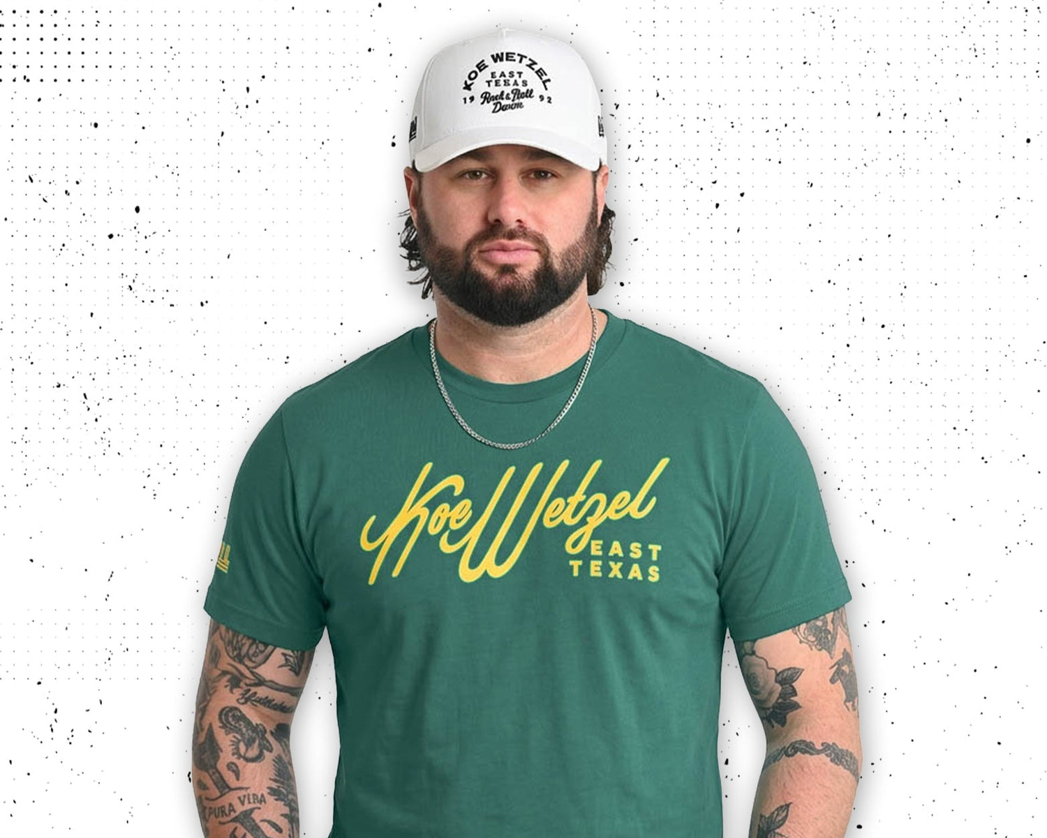 Koe Wetzel wearing a green t-shirt with yellow text and a white cap on a white background