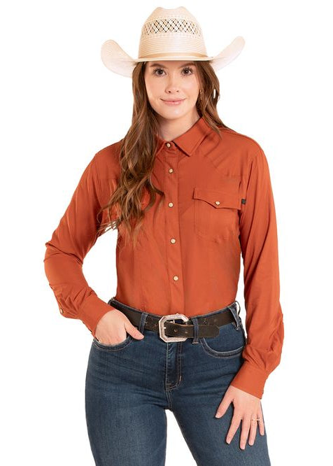 Woman wearing a rust-colored button-up shirt and blue jeans with a cowboy hat on a white background