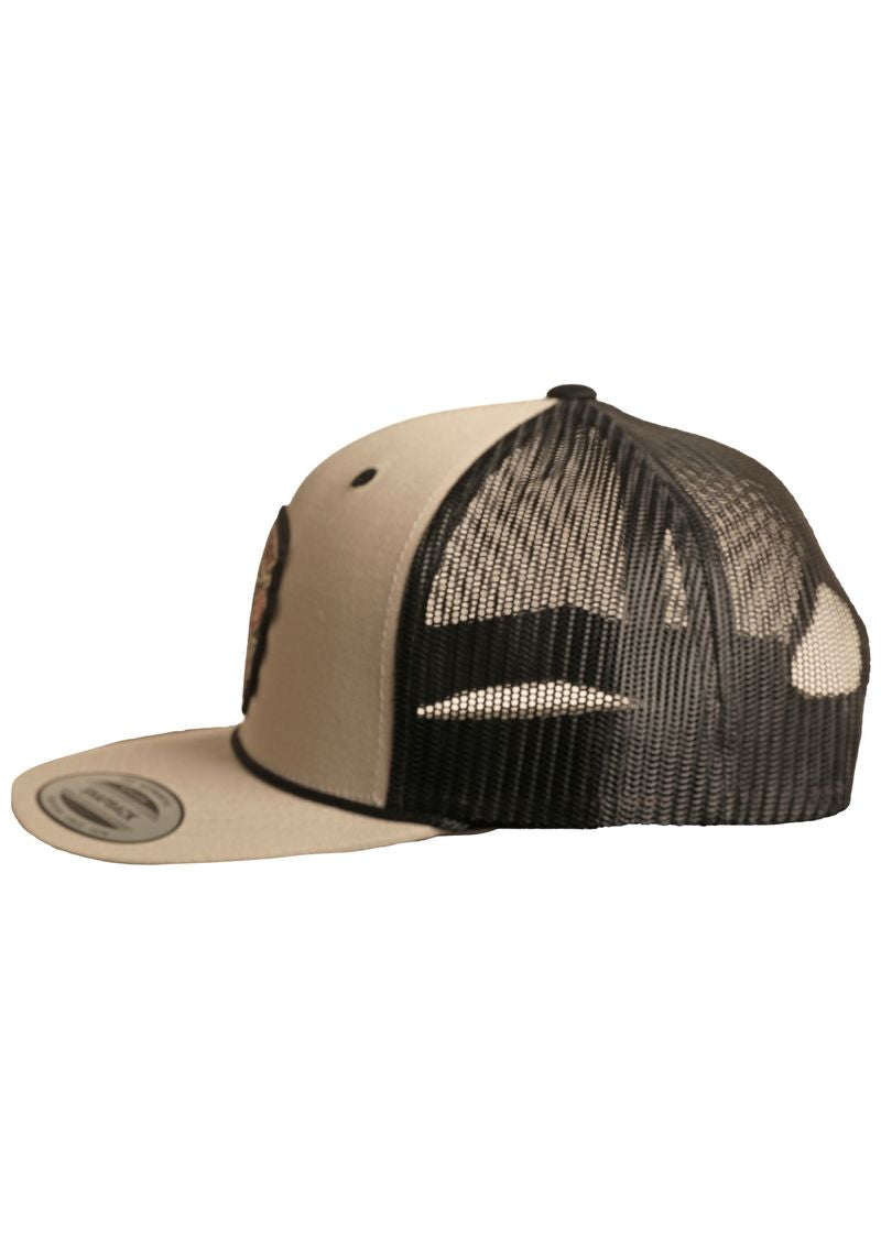 The Dale Brisby Rodeo Time Cap by Rock & Roll Denim is beige and black with a flat brim, mesh back panels, and an adjustable snapback closure—shown from the side.
