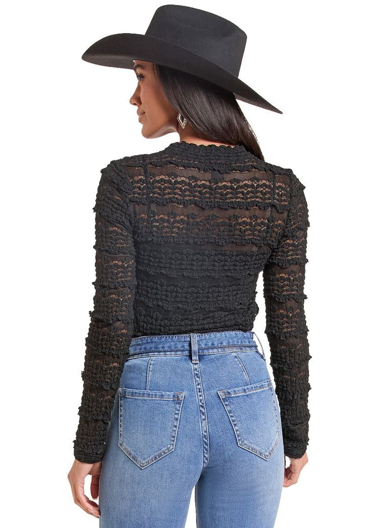 The back of a woman wearing a long sleeve lace shirt. 