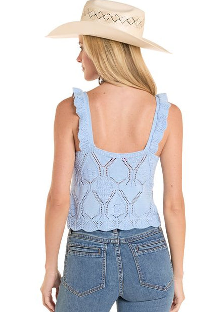 Woman wearing a light blue sleeveless top and jeans with a beige hat on a white background