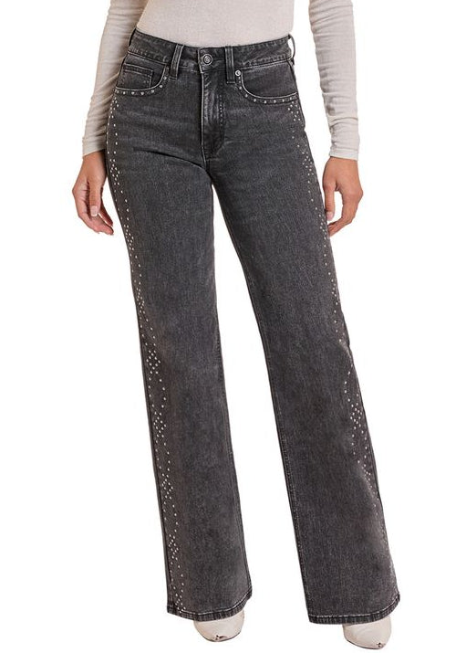 Woman wearing a pair of black studded jeans.
